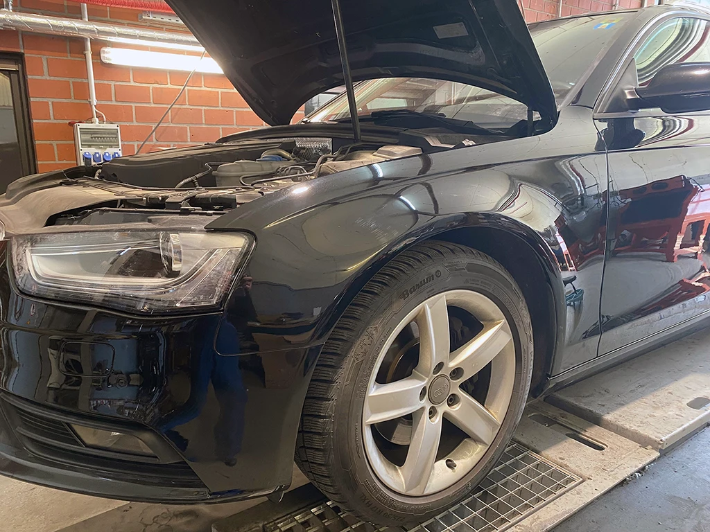 Schwarzer Audi nach fachgerechter Seitenschaden-Reparatur in der Autohaus Marpert Werkstatt.